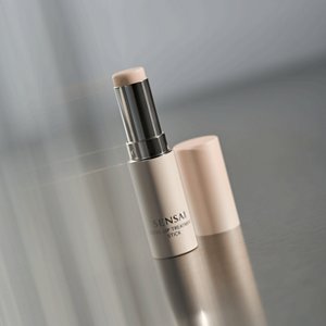 Total Lip Treatment Stick Spender geöffnet sichtbar, um die Textur auf einem grauen abstrakten Hintergrund zu zeigen